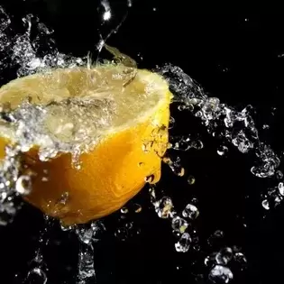 photo of a lemon with water splashing off of it